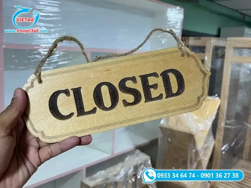 Bảng hiệu gỗ treo ở cửa ra vào