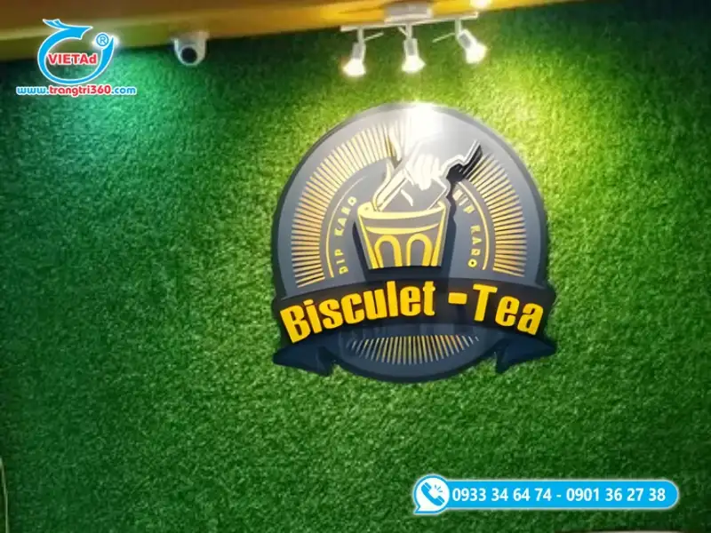 Bảng hiệu cỏ nhân tạo kết hợp logo nổi 3D và đèn chiếu sáng, tạo hiệu ứng sang trọng