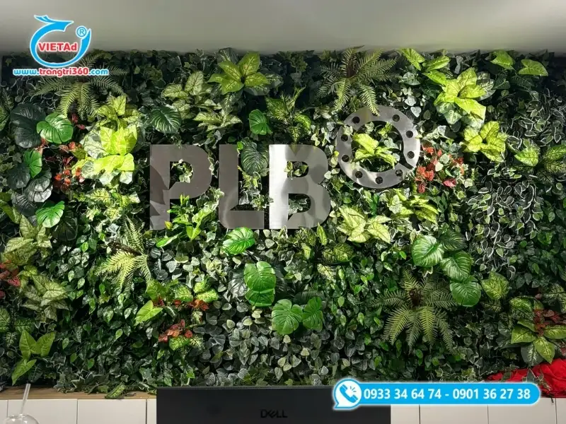 Bảng hiệu nền cỏ nhân tạo kết hợp cây giả trang trí, nền alu đen và chữ inox nổi tạo cảm giác xanh mát, hiện đại