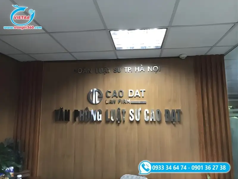 Vách logo văn phòng luật sư với chữ nổi inox bạc gắn trên nền gỗ