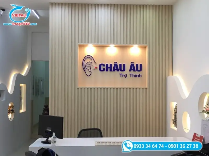 Mẫu vách logo phòng lễ tân trung tâm trợ thính với chữ nổi mica xanh kết hợp đèn hắt sáng