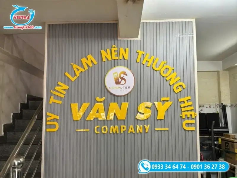 Vách logo công ty chữ nổi inox vàng nổi bật trên nền lam sóng trang trí,
