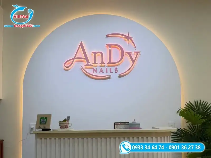 Bảng hiệu nail trong nhà nổi bật với vách thạch cao uốn vòm và chữ Mica hồng hắt sáng chân LED tinh tế