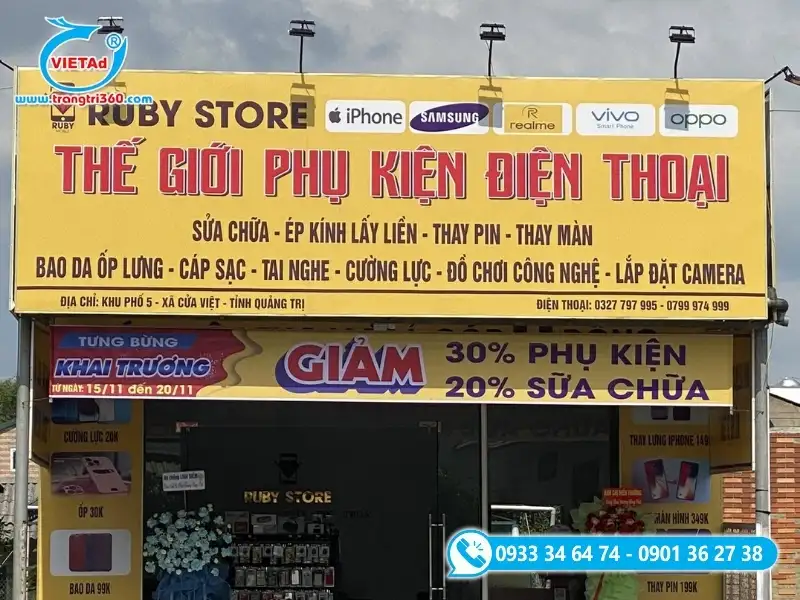Băng rôn quảng cáo khuyến mãi phụ kiện điện thoại treo dưới bảng hiệu lớn