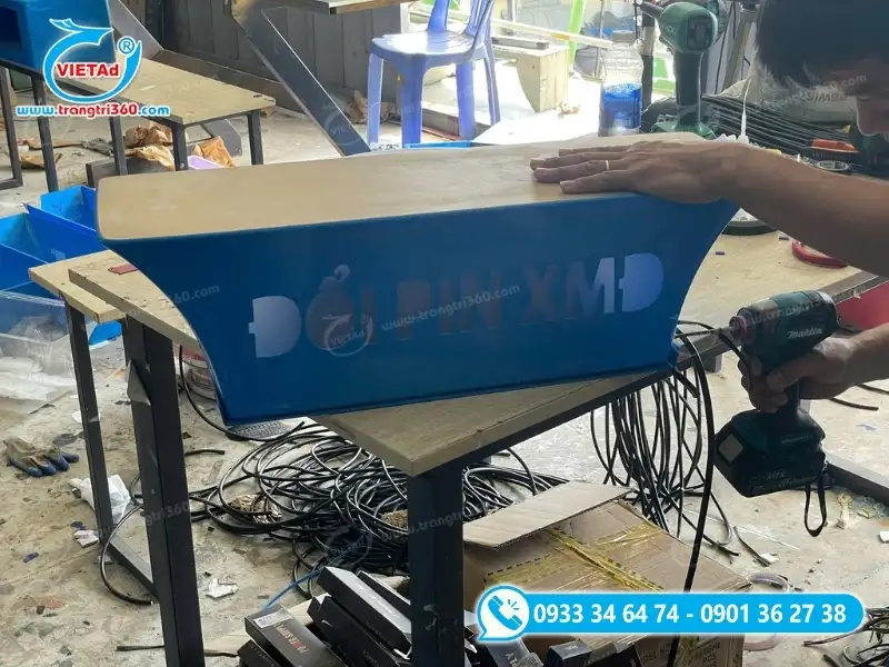 Kỹ thuật viên tiến hành khoan lỗ đi dây đèn LED cho hộp đèn
