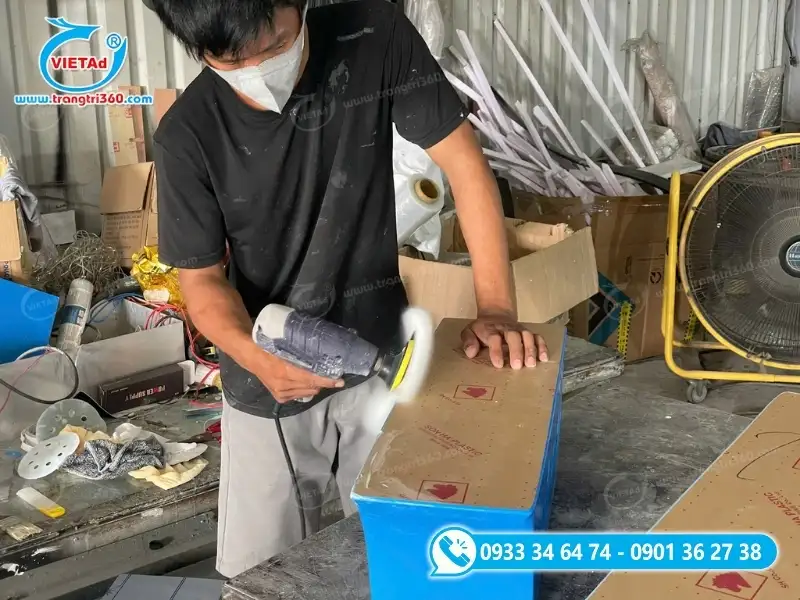 Hình ảnh nhân viên kỹ thuật Quảng Cáo Việt thao tác dán keo và vệ sinh hộp đèn